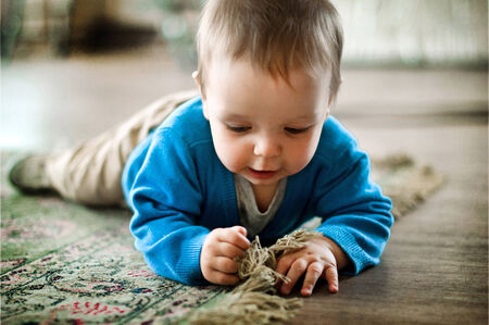 little boy playing on the floor at homeの写真素材