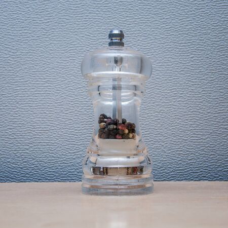 colored peppers in a transparent millの写真素材