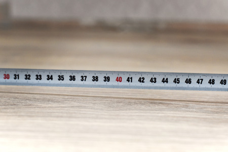 carpenter's tape measure on wooden floor closeupの写真素材