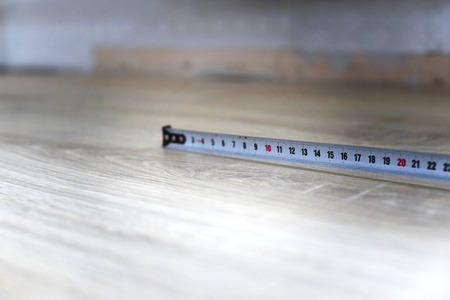 carpenter's tape measure on wooden floor closeupの写真素材
