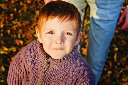 boy looks at camera in autumn Park