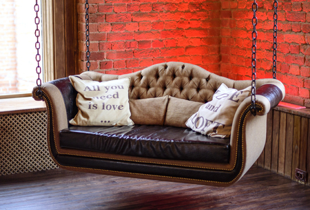 sofa hung on chains in a modern loftの写真素材