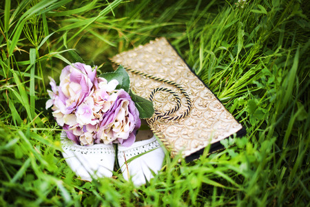 wedding shoes and wedding bouquet in the grassの写真素材