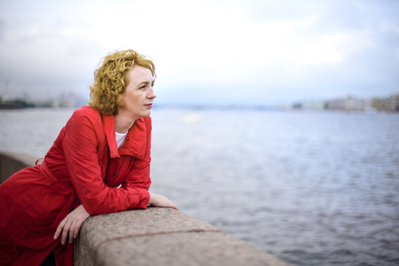 young woman in red coat  in cityの写真素材