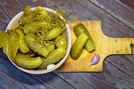 Homemade pickled cucumbers with herbs and spices. On a wooden background.の写真素材