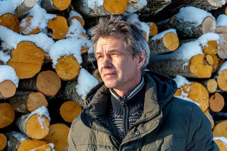 Freshly cut logs and firewood from loggers submerged under a blanket of white snow during the winter season.の写真素材