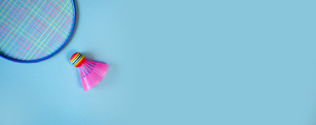 Pink badminton shuttlecock and racket on a blue background. Concept: minimalism, summer outdoor gamesの写真素材