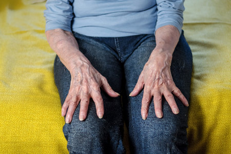 hands of an elderly woman lie on denim clothes