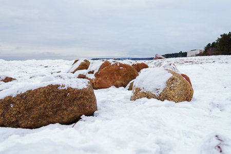 Rocks on the snow-covered shore of the Baltic Bay.