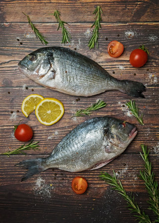 Fresh dorado fish. Dorado and ingredients for cooking on a wooden tableの写真素材