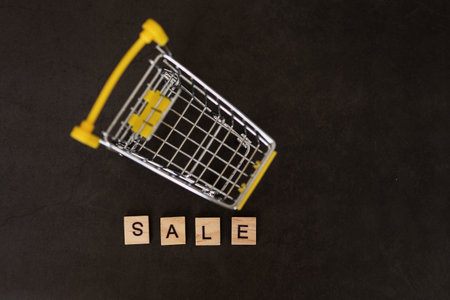 Season of sales in online stores. Cart and sales word on dark blue background. Creative idea for a sale, promotion, or concept for cyber Monday or black Fridayの写真素材