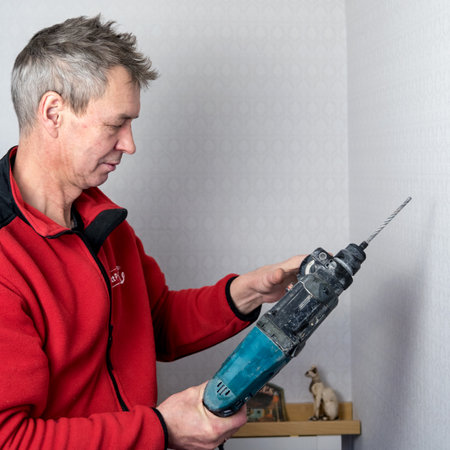 Portrait of a man with a drill in his hands. A man during a pandemic makes home repairs himself.の写真素材