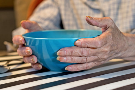 elderly woman holding a bowl of soup.