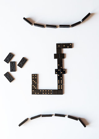 Family entertainment for a fun leisure game of dominoes. The bones are laid out on a white...