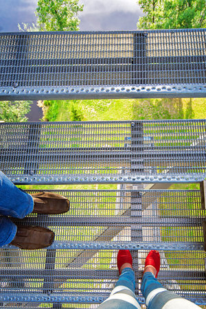 Travelers' feet stand on a platform on a high mountain, enjoying a good view. The concept of travel,...