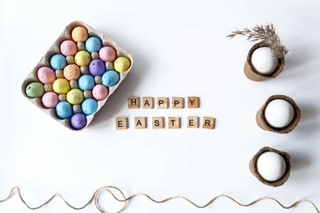 Easter concept with colored and white eggs on a white background. Happy Easter inscription