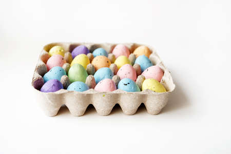 Colored willow branch and colored eggs in a cage of eggs. Happy Easter concept.