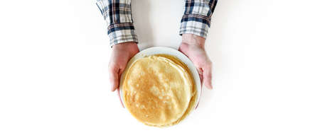 Banner with men's hands. Hold a white plate with lots of pancakes.の写真素材