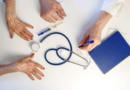Hands of an elderly patient and a geriatrician. Top viewの写真素材