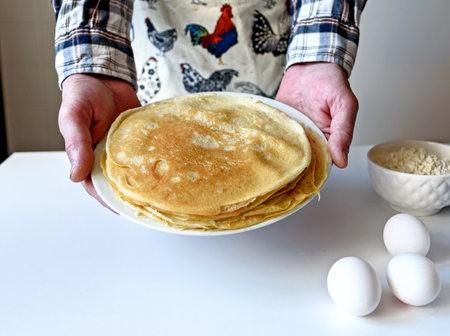 A lot of pancakes are stacked on a white plate. Thin pancakes with a crispy crust. Pancake day....