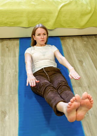 Fitness training of a sports girl. Sports and body care. Fitness at home. The girl trains at home on...