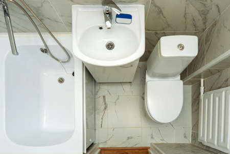Top view of a small white bathroom. An example of a bathroom in a small apartment space