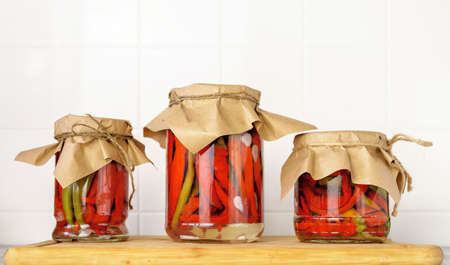 Canned pods of bitter pepper. Chili pepper. Agricultural background with vegetables. Harvesting. Sale of canned vegetables.の写真素材