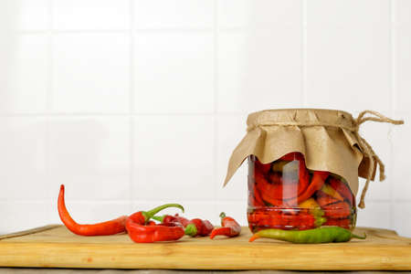 Canned pods of bitter pepper. Chili pepper. Agricultural background with vegetables. Harvesting. Sale of canned vegetables.の写真素材