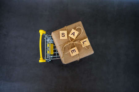 Shopping basket with gift box in waxed paper. The Concept Of Online Shopping. Christmas sales or gift shopping. Sale for New Year and Christmas. Buying gifts.の写真素材