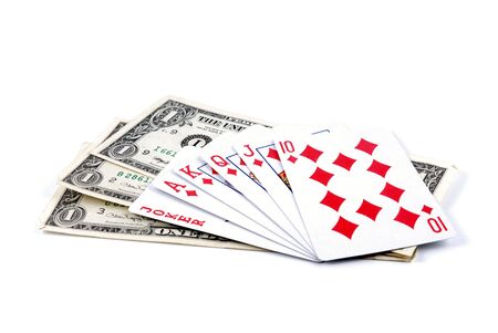 Three denominations on one dollar laid by a fan and playing cards on a white background