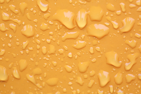 Rain water drops on yellow backgroundの写真素材
