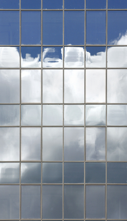 Clouds reflected in windows in the office buildingの写真素材