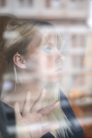 Art portrait of beautiful blonde through the glassの写真素材