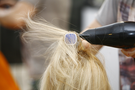 Hairstylist Drying Hair Blonde in Salon for short hairの写真素材