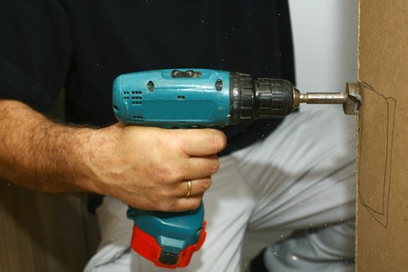 the master working with drill over new kitchen casesの写真素材