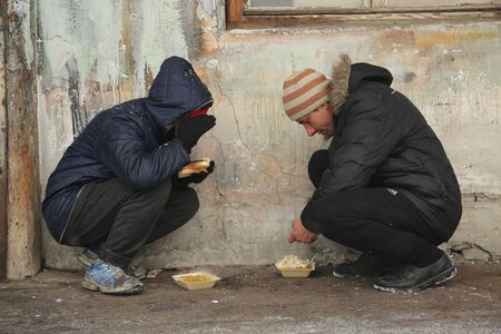 Belgrade, Serbia - January 10, 2017: A migrant eats free food during a snowfall outside a derelict...