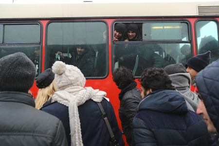 Belgrade, Serbia - January 17, 2017: Face of migrant behind the buses glass. Almost 200 refugees moved from the warehousein Belgrade, to the new refugee center in the Obrenovac with buses.のeditorial素材