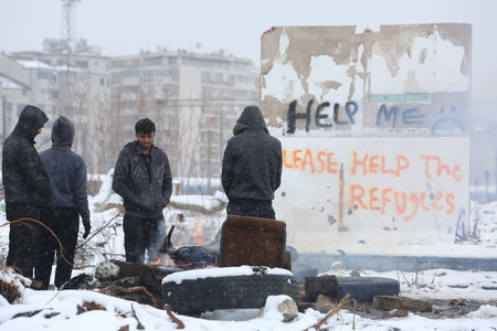 Belgrade, Serbia - January 18, 2017: Refugees warm outside near graffiti on the wall to help refugees in Belgrade. Migrants mostly from Afghanistan and Pakistan in Belgrade they seek ways to move on toward Western Europe.のeditorial素材