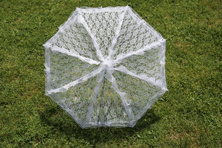 White lace umbrella on grass.の写真素材