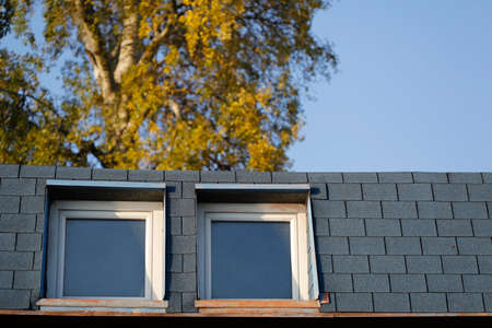 Summer sun reflection on attic windows. Gray brick pattern.の写真素材