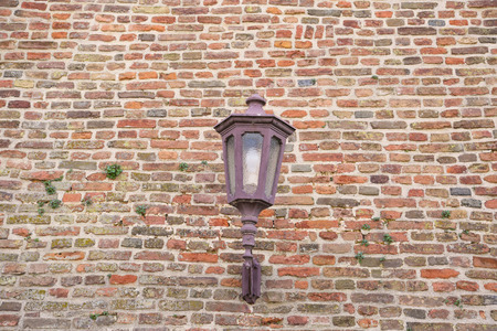 Texture of old hanging lantern on fortress brick wall pattern.の写真素材