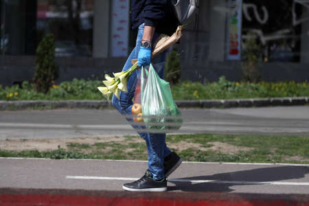 BELGRADE, SERBIA - MARCH 28, 2020: Woman with surgical gloves and food. As the Corona Virus...