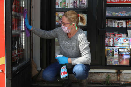 BELGRADE, SERBIA - MARCH 28, 2020: Worker woman cleans the window. As the Corona Virus continues to...