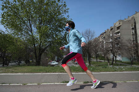 BELGRADE, SERBIA - MARCH 28, 2020: Woman running on street. As the Corona Virus continues to spread...