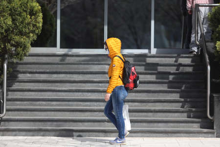 BELGRADE, SERBIA - MARCH 28, 2020: Woman wask mask walking. As the Corona Virus continues to spread...