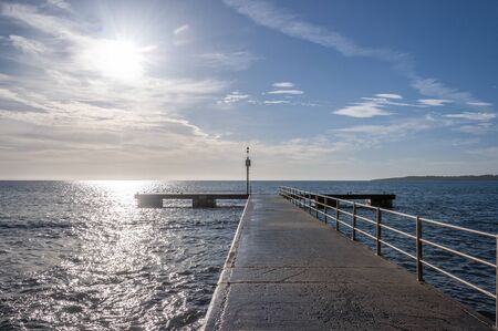 Cala Millor pier at dawn on a sunny day. Mediterranean Sea. Island of Mallorca, Spainの写真素材