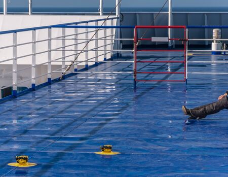 A pair of boots on the blue deck of a ferry. Surrealistic compositionの写真素材