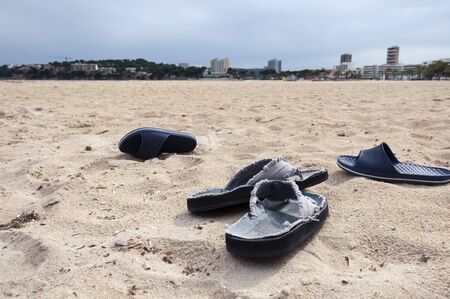 Two pairs of flip-flops abandoned on the beach. Quarantine caused by the Coronavirus crisisの写真素材