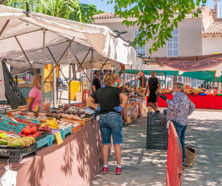 Sineu, Balearic Islands/Spain; may/20/2020: fruit and vegetable stall at the traditional street market in Sineu. Seller and buyers with gloves and masks for the new social measures by the Covid-19のeditorial素材