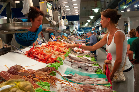Palma de Mallorca, Balearic Islands / Spain; july 2014: woman buying at a fish stall in the Mercado del Olivar, Palma de Mallorcaのeditorial素材